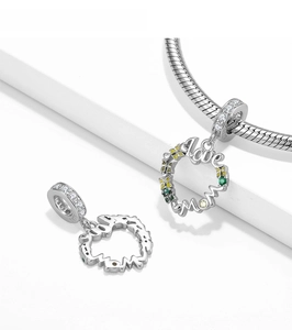 Macro detail of 925 silver heart charms with Love Mom engraving and enamel flowers