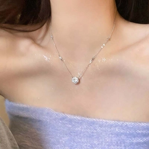 Detail showing the silver pearl pendant necklace on a neck with a purple velvet top