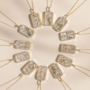 Golden zodiac necklaces with colorful stones and shell pendants in a circular layout