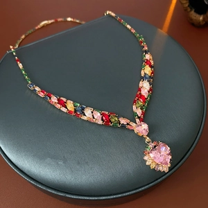 Detailed view of heart-shaped pink gem pendant necklace with colorful zircons on display