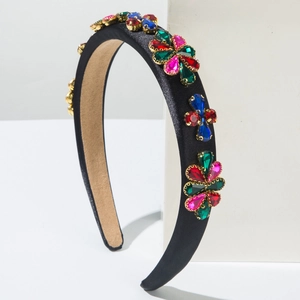 Détail de fleurs en strass colorés sur un serre-tête baroque rembourré en satin noir
