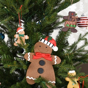 Classic gingerbread man Christmas ornaments hanging on a festive green pine tree
