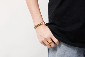Golden watchband style bracelet and ring set for men shown on model's hand