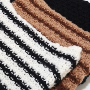 Striped knit beanie with devil ears in black, white, and brown thick yarn texture