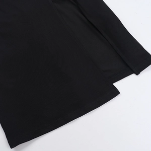 Détail de la fente latérale et des coutures fines à double aiguille sur robe noire