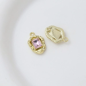 Macro detail of gold irregular frame pendant with pink rectangular gem for DIY jewelry
