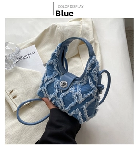Detailed view of blue denim quilted handbag with white stitching and silver twist lock