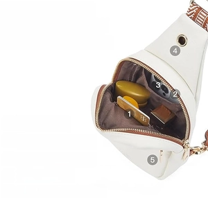 Detailed view of white canvas crossbody bag showing large capacity with numbered pockets