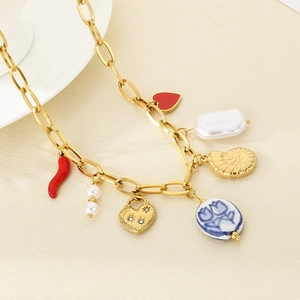 Detailed shot of gold necklace with colorful charms like shell, heart, and chili pendants