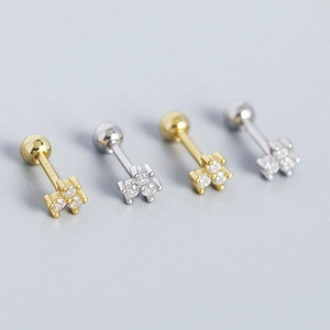 Macro shot of 925 silver stud earrings with small zircon stones in gold and silver finish