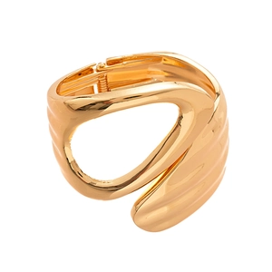 Modern irregular sculptural gold cuff bracelet with wavy texture on white background