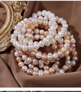 Macro detail of natural freshwater pearls in multi-color on elegant brown silk fabric