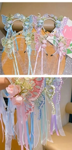 Detail of embroidered butterfly hair hoop with faux flowers, pearls and ribbon tassels