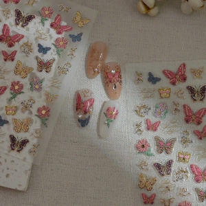 Détail des stickers ongles 5D papillon en relief doré avec fleurs et perles de nacre