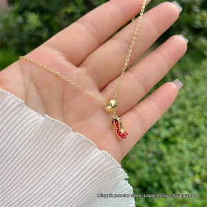 Dettaglio della collana placcata oro 18K con ciondolo a scarpa rossa a pois bianchi