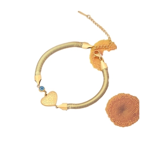 Golden snake chain necklace with heart pendant and blue evil eye bead on white background