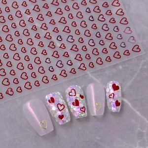 Detail showing red heart nail stickers applied on aurora and glitter false nails