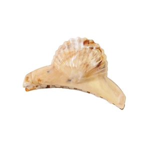 Close-up of a shell-shaped hair claw clip with beige and brown marble texture details