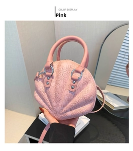 Detailed pink shell handbag featuring delicate lace floral embroidery and metal rings