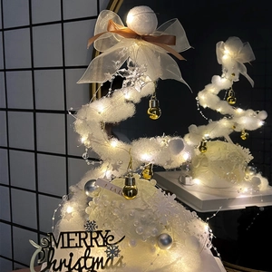 Fluffy white Christmas tree detail with fairy lights and bows, perfect holiday cake decor.