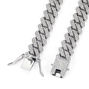 Detailed close-up of a silver Cuban link chain with sparkling pavé-set stones and box clasp