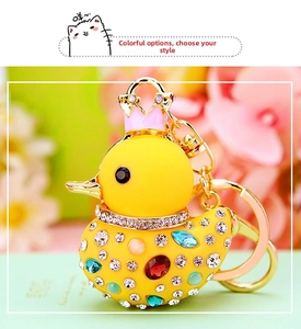 Close-up of sparkling rhinestone yellow duck keychain with pink crown and golden ring