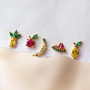 Macro shot of assorted gold-plated fruit stud earrings with colorful zircon stones