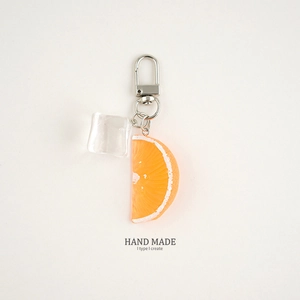 Macro shot of realistic orange slice and ice cube keychain with clear metal clasp