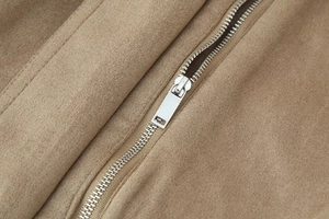 Detailed close-up of premium khaki suede jacket fabric with smooth silver metal zipper