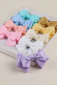 Détail de nœuds en tissu à volants colorés disposés dans un cadre photo blanc élégant