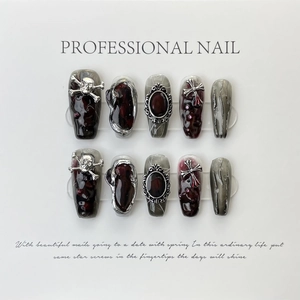 Gothic handmade press-on nails with dark marble texture and metal skull accents