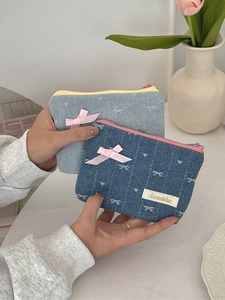 Handheld denim coin pouches with bow embroidery and zippers in light and dark blue