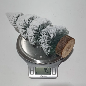 Detailed view showing the 49.7g weight of a mini cedar Christmas tree with snow effects
