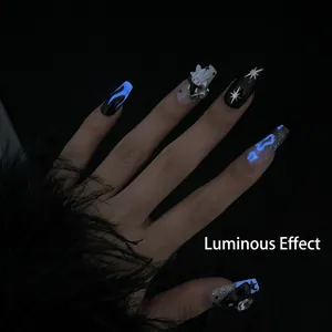 Luminous hand-painted black press-on nails with blue glow effect and star patterns
