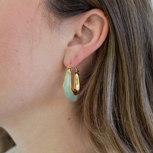 Elegant gold C-shaped resin heart earrings on model for a vintage minimalist look