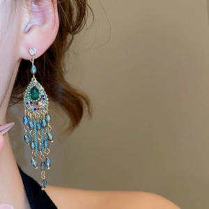 Detail showing vintage emerald waterdrop earrings with long crystal tassel fringe