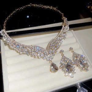 Detailed macro view of vintage gold necklace set with teardrop crystals on velvet tray