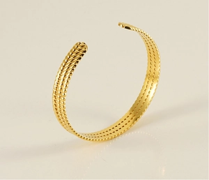 Detailed view of gold twisted rope texture on an adjustable open bangle bracelet