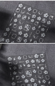Macro view of white floral embossed 3D nail stickers with elegant flower patterns