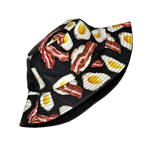 Detail of creative fried egg and bacon print on black canvas bucket sun hat