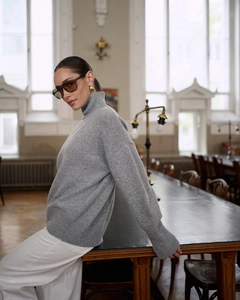 Macro detail of the grey turtleneck sweater showing premium knit texture and ribbed collar