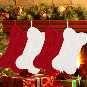 Primer plano de cuatro calcetines de Navidad tejidos en forma de hueso en una chimenea