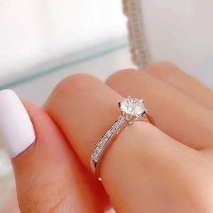 Classic six-prong solitaire ring with micro-paved side stones on a silver band