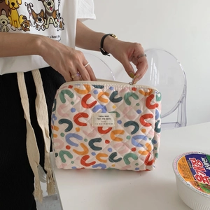 Quilted floral makeup bag with colorful wave patterns and a secure metal zipper