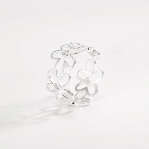 Macro shot of silver cutout floral ring with white zircon stones and intricate flower detail