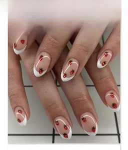 Detail of JP3911 French tip press-on nails with red strawberry pattern and almond shape