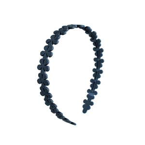 Detail of dark blue matte acrylic headband featuring a continuous small flower design