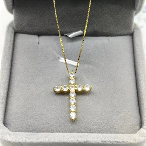 Elegant gold cross pendant necklace with clear sparkling stones in a jewelry gift box