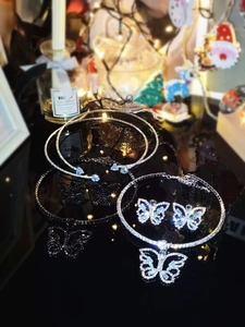 Detailed close-up of sparkling rhinestone choker necklaces and earrings on black mirror surface