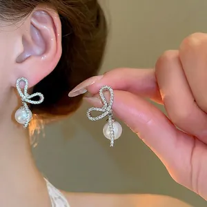 Elegant silver bow earrings with sparkling cubic zirconia and drop pearls for women